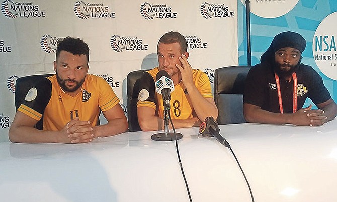 Happy Hall (centre) speaks to the media as teammate Cameron Hepple (left) and head coach Nesly Jean (right) look on.