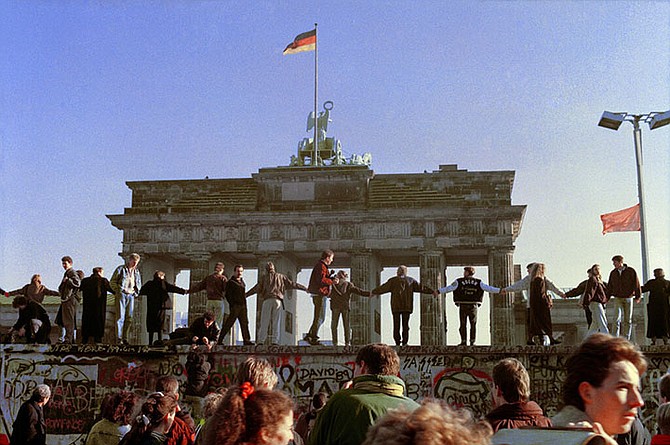 Berliners sing and dance on top of the Berlin Wall to celebrate the opening of East-West German borders in Berlin on November 10, 1989.