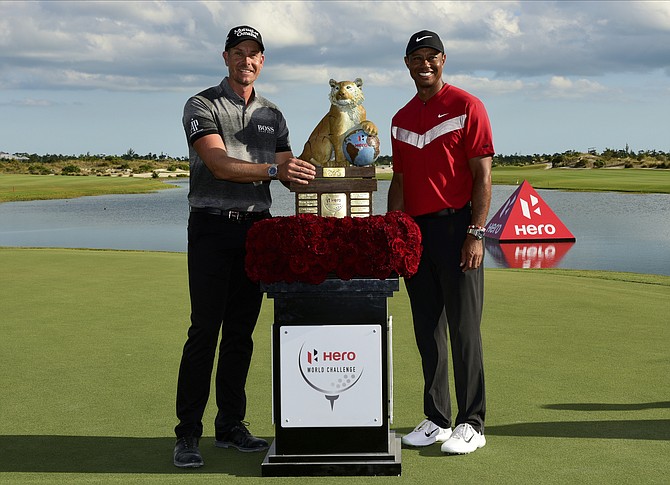 Henrik Stenson, left, poses with Tiger Woods, after winning the Hero World Challenge at the Albany Golf Club Saturday. (AP Photo/Dante Carrer)