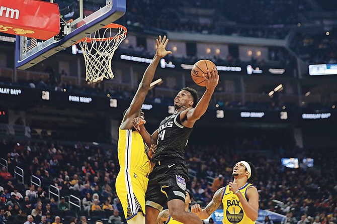 Sacramento Kings guard Buddy Hield (24) shoots against Golden State Warriors forward Damion Lee (1) during the first half last night in San Francisco. Hield also had four rebounds, four assists and two steals.

(AP Photo/Jed Jacobsohn)
