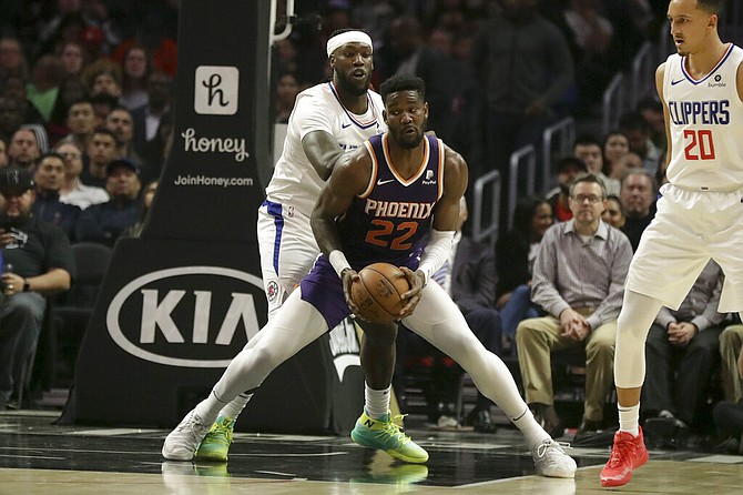 Phoenix Suns centre Deandre Ayton drives around Los Angeles Clippers forward Montrezl Harrell during the first half of an NBA basketball game in Los Angeles, Tuesday. (AP Photo/Chris Carlson)