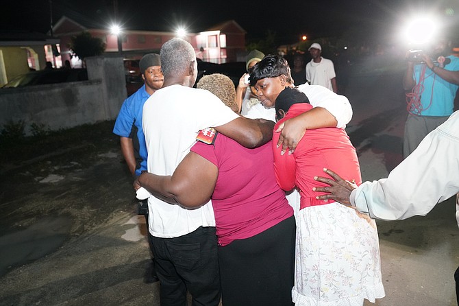 Distraught people at the scene after the year’s first murder.