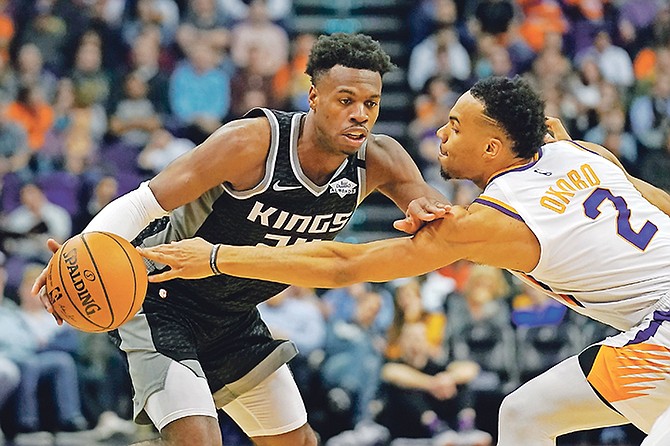 Kings guard Buddy Hield gets pressured by Suns forward Elie Okobo (2) in the first half last night in Phoenix. The Kings won 114-103.

(AP Photo/Rick Scuteri)