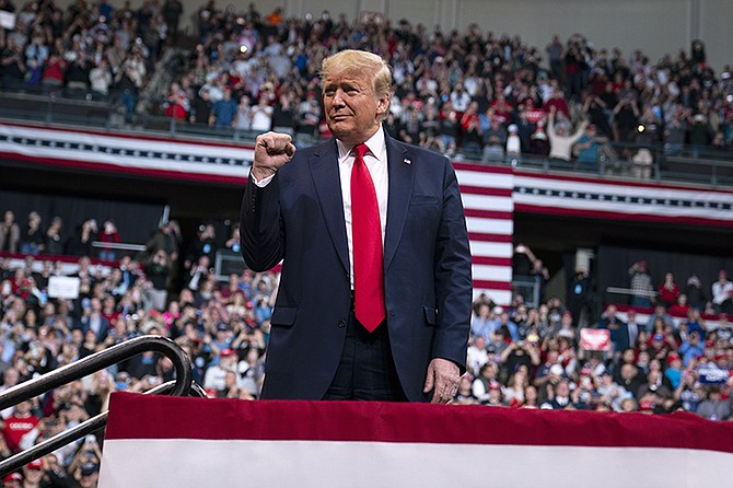 President Donald Trump gestures to supporters during a campaign rally in New Hampshire.