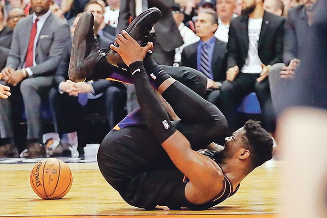 OUCH: Phoenix Suns centre Deandre Ayton grabs his foot after being injured during the second half against the Toronto Raptors on Tuesday night in Phoenix. The Raptors won 123-114.  (AP Photo/Matt York)