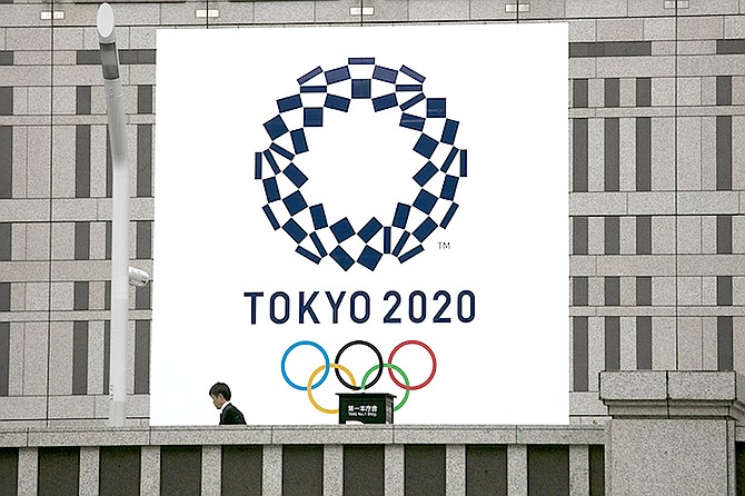A man walks past a large banner promoting the Tokyo 2020 Olympics in Tokyo, Monday. (AP)