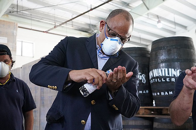 Health Minister Dr Duane Sands tries out the hand sanitizer being developed by John Watling’s Distillery. Photos: Terrel W Carey Sr/Tribune staff