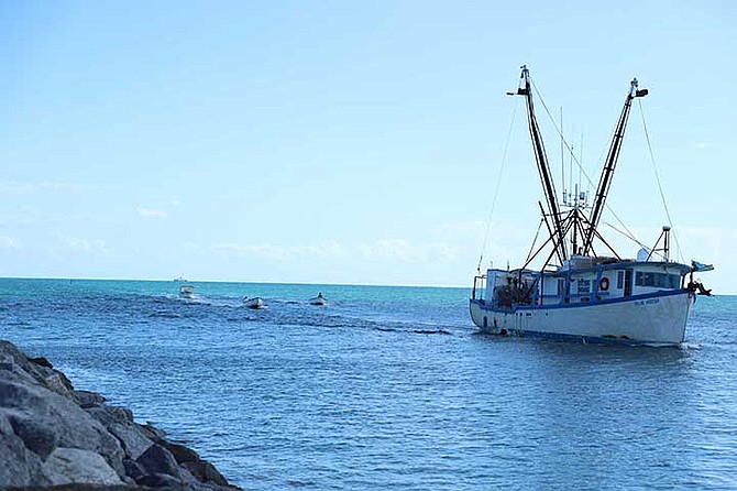 A Bahamian fishing vessel with several skiffs makes its way into HMBS Coral Harbour after the crew and vessel were apprehended for fishing violations, fishery products on one of the vessels, a compressor on one of the vessels, and a skiff with a compressor.