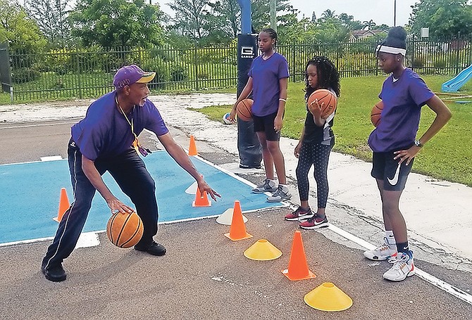 COORDINATOR Terrance ‘Red Eye’ McSweeney shows Raven Jones, Marcia Hall and Jasmin Roker how to dribble the ball.