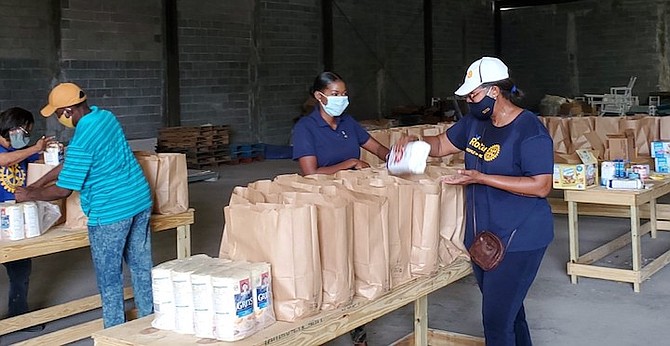 Christine van de Linde, Immediate Past President of Rotary Club of Grand Bahama (far right) and other Rotarians busy packing food parcels for distribution to needy families in Freeport.