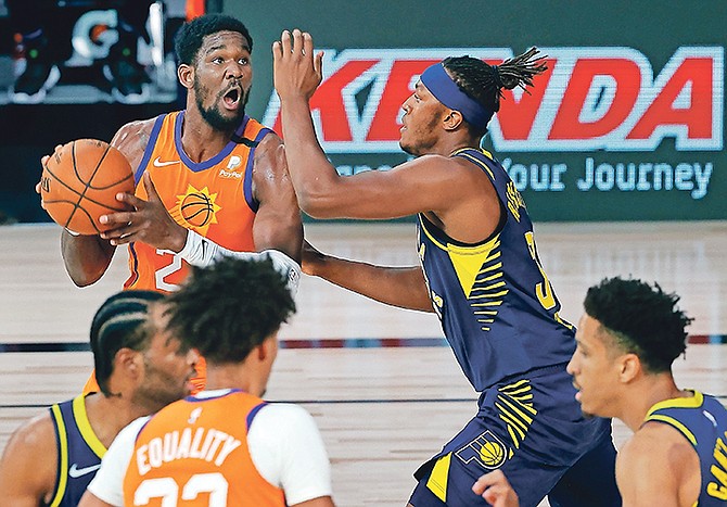 Phoenix Suns’ Deandre Ayton (22) drives to the basket as Indiana Pacers’ Myles Turner (33) defends during the first half of an NBA basketball game Thursday, Aug. 6, 2020, in Lake Buena Vista, Fla. (Kevin C. Cox/Pool Photo via AP)