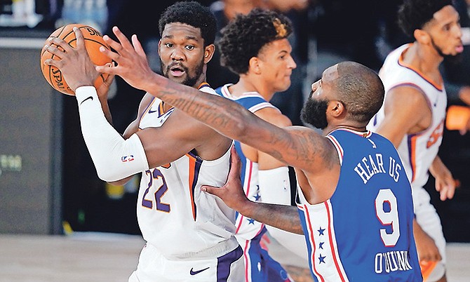 Phoenix Suns centre Deandre Ayton (22) looks for help as Philadelphia 76ers centre Kyle O’Quinn (9) applies pressure during the second half yesterday in Lake Buena Vista, Florida.

(AP Photo/Ashley Landis)