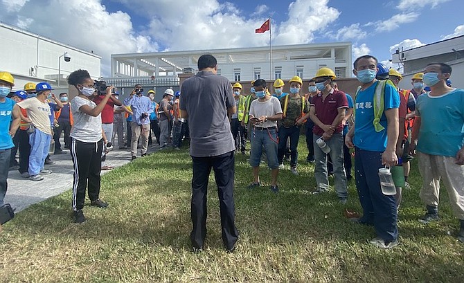 Chinese workers from The Pointe outside the Chinese Embassy on Tuesday.