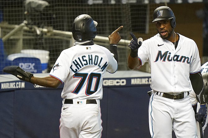 Miami Marlins' Jazz Chisholm (70) is congratulated by Starling Marte after scoring on a single by Corey Dickerson during the third inning of the first game of a baseball doubleheader against the Philadelphia Phillies, Sunday, Sept. 13, 2020, in Miami. (AP Photo/Wilfredo Lee)