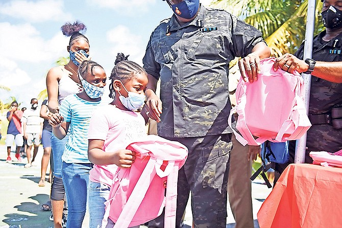 POLICE officers distribute school supplies yesterday at Pinewood Park.