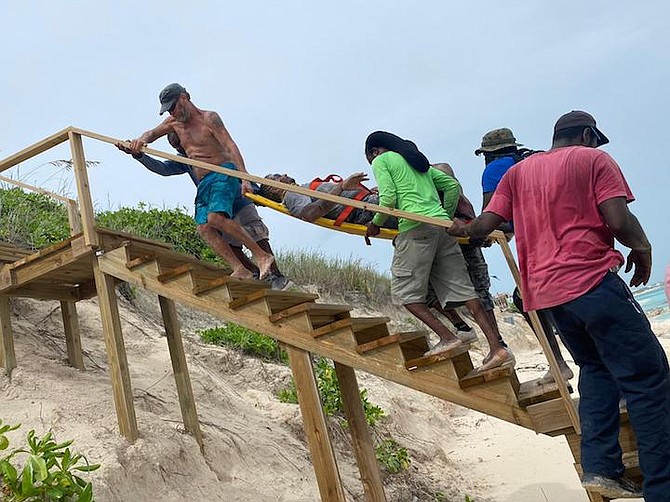 ROYAL Bahamas Defence Force Marines, police and local community members rescue a man who was partially buried under the sand on Saturday. Photo: Able Seaman Michael Turner II/RBDF