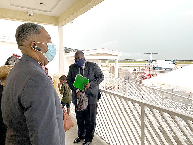 Minister of Social Services and Urban Development Frankie Campbell (foreground), waits for the 30 children from the Grand Bahama Children’s Home to disembark from Bahamasair Flight 315 at the Grand Bahama Airport following a rain delay. The children were safely returned to Grand Bahama and handed over to administrators and staff of the Grand Bahama Children’s Home. (BIS Photo/Lisa Davis)