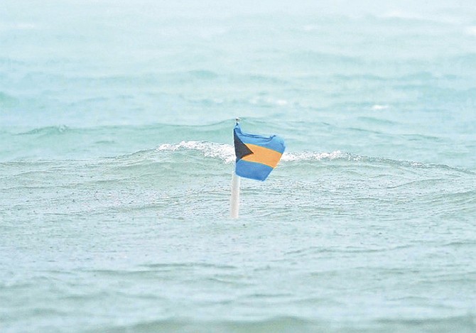 A BAHAMAS flag flutters above the flood waters . . . just.
Photo: Terrel W Carey Sr/Tribune Staff