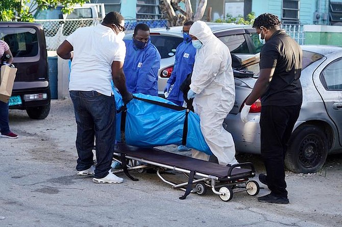 One of the bodies is removed from the scene. Photo: Terrel W Carey Sr/Tribune staff