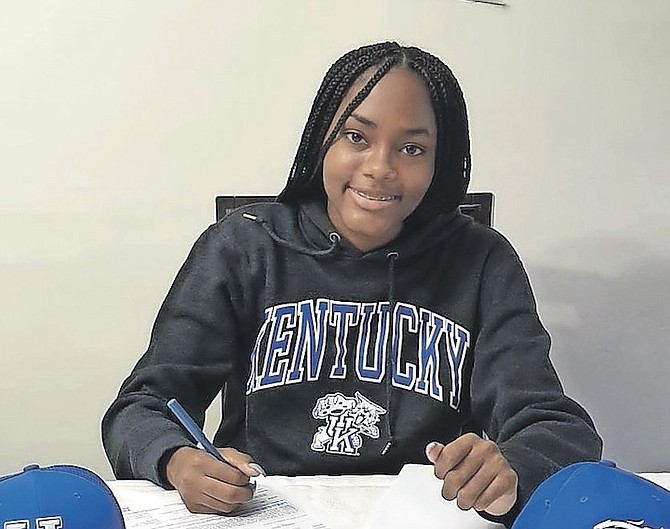 ANTHAYA Charlton signs her scholarship form for the University of Kentucky.
