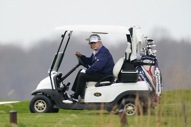 PRESIDENT Donald Trump drives a golf cart as he golfs at Trump National Golf Club in Sterling,
Virginia, on Sunday. Photo: Manuel Balce Ceneta/AP
