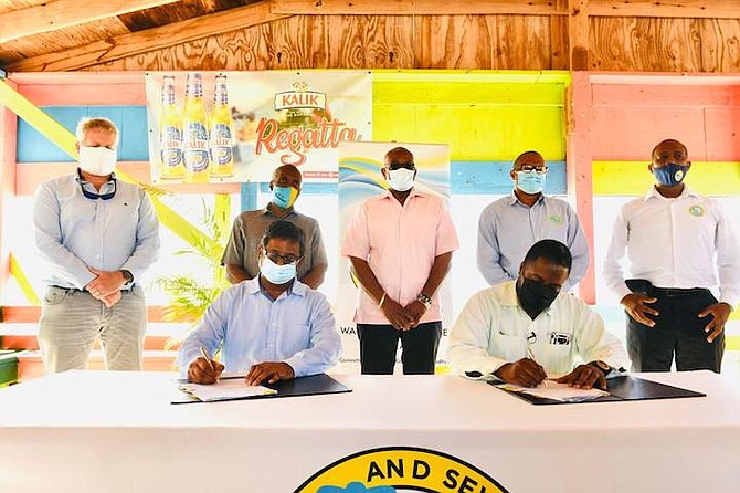 Executive chairman of the Water and Sewerage Corporation Adrian Gibson, seated right, at the Cat Island water supply contract signing in Cat Island yesterday.  Prime Minister Dr Hubert Minnis, standing centre, with ceremony officials, gave an address. Photo: Yontalay Bowe/BIS