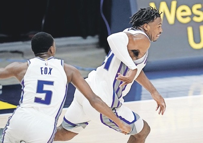 SACRAMENTO Kings guard Buddy Hield, right, reacts after putting in the winning basket in overtime against the Denver Nuggets last night in Denver. Sacramento guard De’Aaron Fox is at left. 
(AP Photo/David Zalubowski)