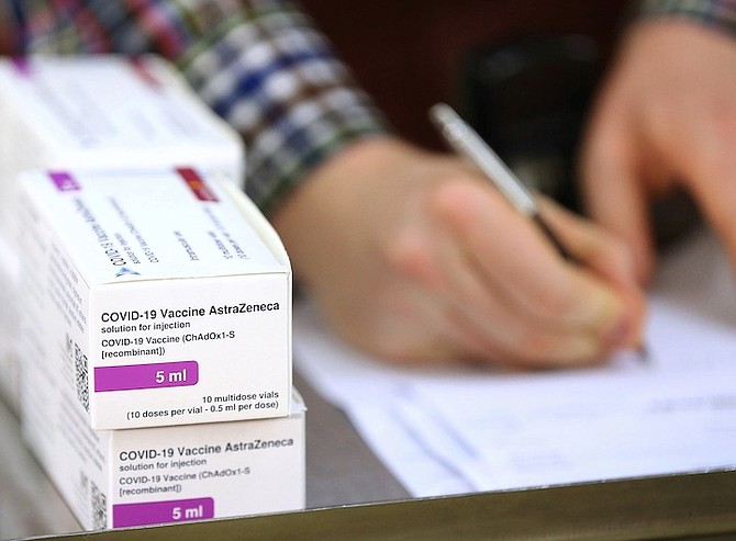 DOSES of the COVID-19 vaccine developed by Oxford University and UK-based drugmaker AstraZeneca are logged by a technical officer, as they arrive at the Princess Royal Hospital in Haywards Heath, England, on Saturday. The UK has 530,000 doses available for rollout from today. Photo: Gareth Fuller/Pool via AP