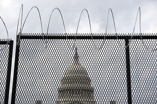 The U.S. Capitol is seen behind a fence with barbed wire in Washington Friday. (AP Photo/Jose Luis Magana)