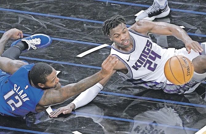 ORLANDO Magic forward Gary Clark (12) and Sacramento Kings guard Buddy Hield (24) compete for a loose ball during the first half last night in Orlando, Florida.
Hield scored 29 points to lead the Kings to victory. (AP Photo/Phelan M Ebenhack)