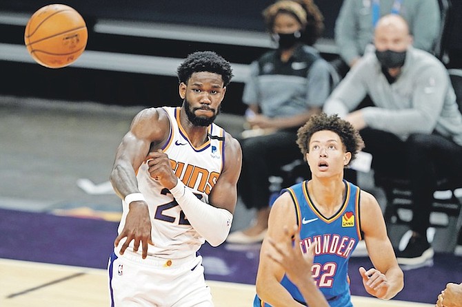 SUNS centre Deandre Ayton passes as Thunder forward Isaiah Roby, right, defends during the second half last night in Phoenix. Ayton scored five points and pulled down 14 rebounds with a steal and four turnovers in 35 minutes on the court.
(AP Photo/Matt York)