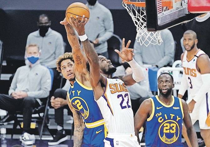 PHOENIX Suns centre Deandre Ayton (22) shoots as Golden State Warriors guard Kelly Oubre Jr (12) tries to block but is called for a foul during the second half last night in Phoenix.
(AP Photo/Matt York)