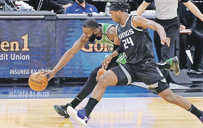 CELTICS guard Jaylen Brown, left, and Kings guard Buddy Hield chase the ball during the first quarter last night in Sacramento.
(AP Photo/Rich Pedroncelli)