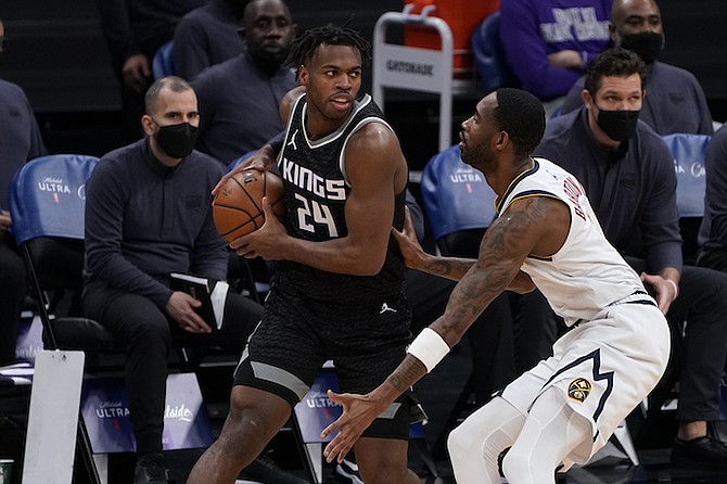 Sacramento Kings guard Buddy Hield, left, looks to pass against Denver Nuggets forward Will Barton, right, during the first half of an NBA basketball game in Sacramento, Calif., Saturday, Feb. 6, 2021. (AP Photo/Rich Pedroncelli)