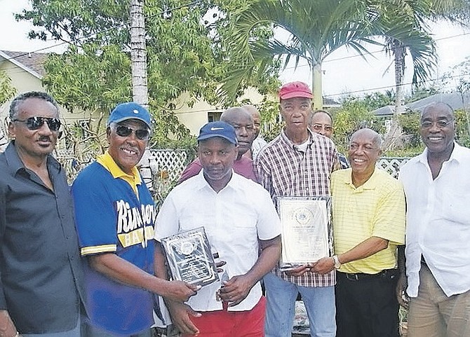 CHARLES ‘Chuck’ Mackey, pictured third from left, was honoured along with Russell Franks by their friends and former Batelco softball team-mates.
