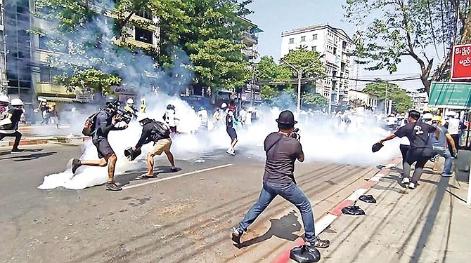 ANTI-coup protesters run away from tear gas launched by security forces in Yangon, Myanmar, yesterday.