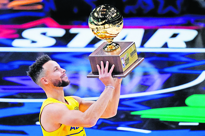 Golden State Warriors guard Stephen Curry holds the trophy after winning the 3-point contest at basketball’s NBA All-Star Game in Atlanta last night.

(AP Photo/Brynn Anderson)