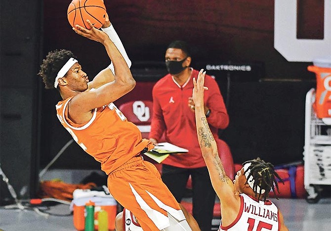 Texas forward Kai Jones (22) shoots the ball over Oklahoma guard Alondes Williams (15) during the first half of an NCAA college basketball game in Norman, Oklahoma on March 4.

(AP Photo/Kyle Phillips)