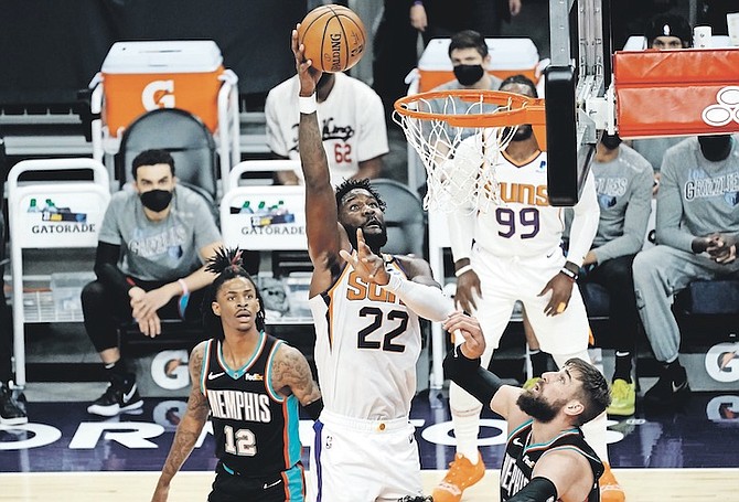SUNS centre Deandre Ayton (22) shoots over Memphis Grizzlies guard Ja Morant (12) and forward Kyle Anderson during the first half on Monday night in Phoenix.
(AP Photo/Rick Scuteri)