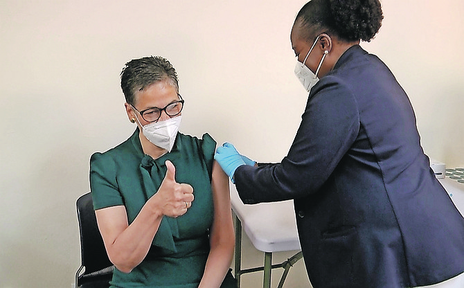 Dr Caroline Burnett-Garaway gives a thumbs up signal as she is vaccinated at yesterday’s session at Princess Margaret Hospital. Photo: Racardo Thomas