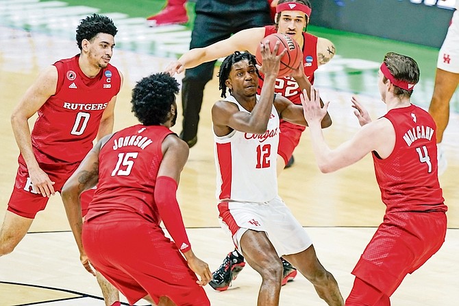 Houston’s Tramon Mark (12) ends up in the middle of a group of Rutgers defenders during the first half of a college basketball game in the second round of the NCAA tournament at Lucas Oil Stadium in Indianapolis on Sunday. Houston won 63-60.

(AP Photo/Mark Humphrey)