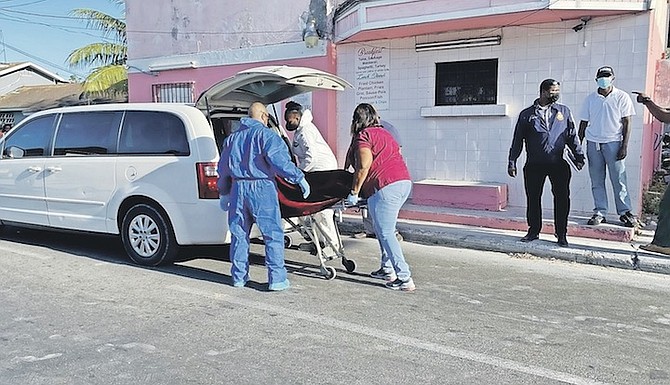 THE BODY of a man who was killed on Saturday being carried away by officials.
Photo: Earyel Bowleg/Tribune Staff