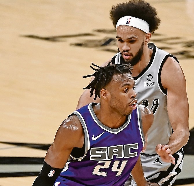 Sacramento Kings’ Buddy Hield (24) drives around San Antonio Spurs’ Derrick White during the second half last night in San Antonio.

(AP Photo/Darren Abate)
