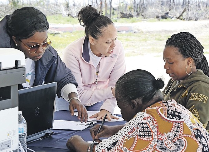 MEMBERS of the RISE team Kerline McPhee, GBPA customer relations officer (top left), with Ashleigh Lockhart, Mercy Corps programme manager (top right), providing one-on-one support to East Grand Bahama residents during a site information session for the RISE Initiative in early 2020, before the onset of COVID-19.