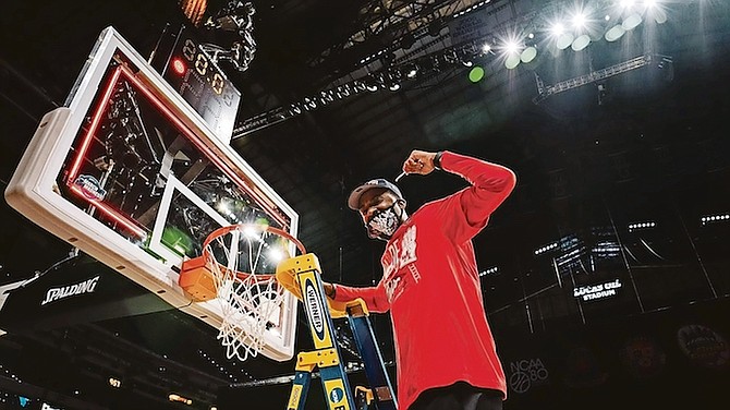 Mikhail McLean cuts down the net following the Houston Cougars’ victory on Monday night.