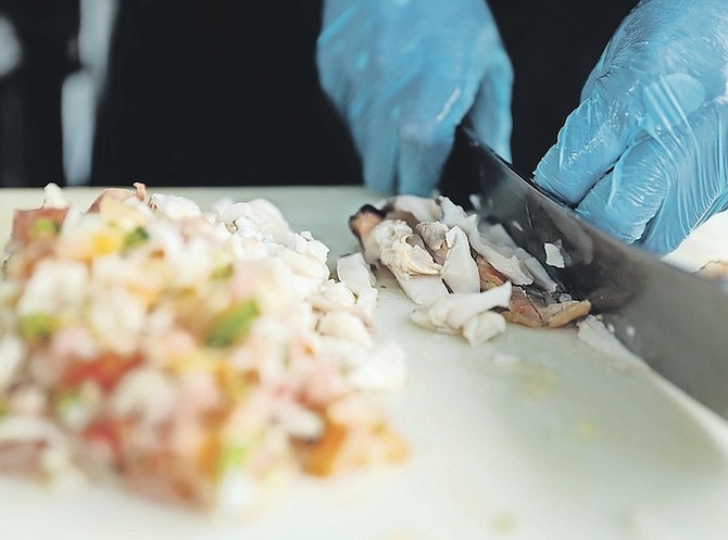 CONCH being prepared yesterday - but officials have issued a warning after several cases of suspected poisoning. Photo: Racardo Thomas