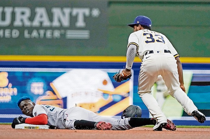INJURED: Miami Marlins’ Jasrado “Jazz” Chisholm Jr steals second with Milwaukee Brewers’ Steve Karsay covering during the first inning last night in Milwaukee. Chisholm Jr beat out an infield single to short, stole second, advanced to third on a groundout and scored on a sacrifice fly by Aguilar. After scoring in the first, Chisholm was replaced at second base in the bottom half of the inning by Jose Devers. Chisholm left with a strained left hamstring, the team announced. (AP Photo/Morry Gash)