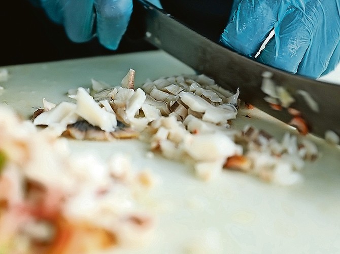 CONCH being prepared at a Potter’s Cay stall. Photo: Donovan McIntosh/Tribune Staff