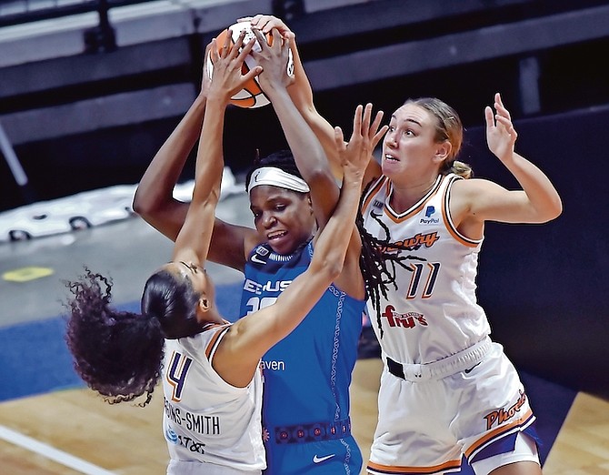 Sun forward Jonquel Jones, centre, is surrounded by Mercury defenders Skylar Diggins-Smith, left, and Alanna Smith, right, in the home opener yesterday in Uncasville, Conn. (AP)
