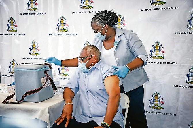 Prime Minister Dr Hubert Minnis leading the way as he receives his second dose of the COVID-19 vaccine earlier this month, administered by nurse Bastian.